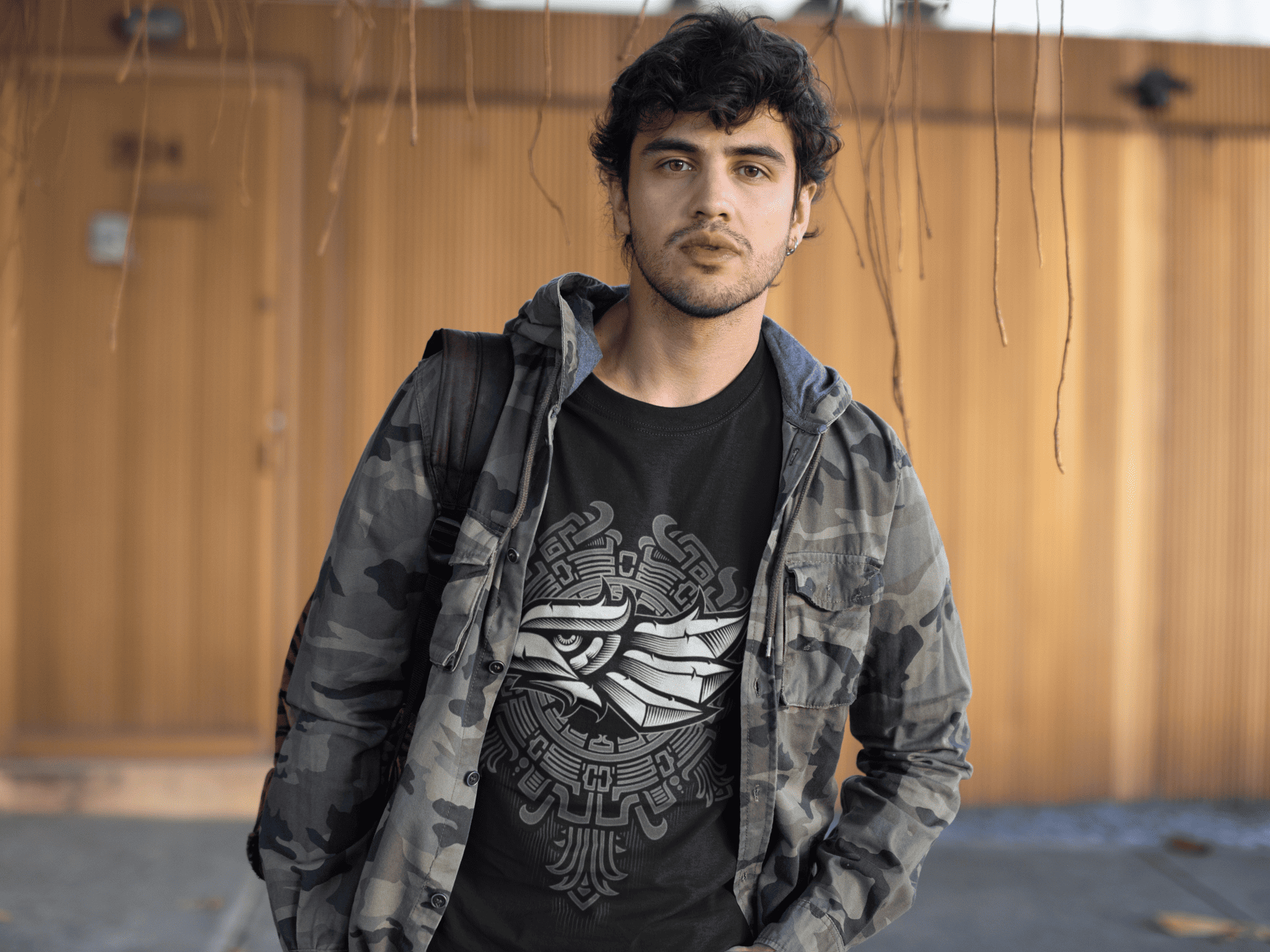 Joven usando playera negra con  diseño de águila azteca moderna 